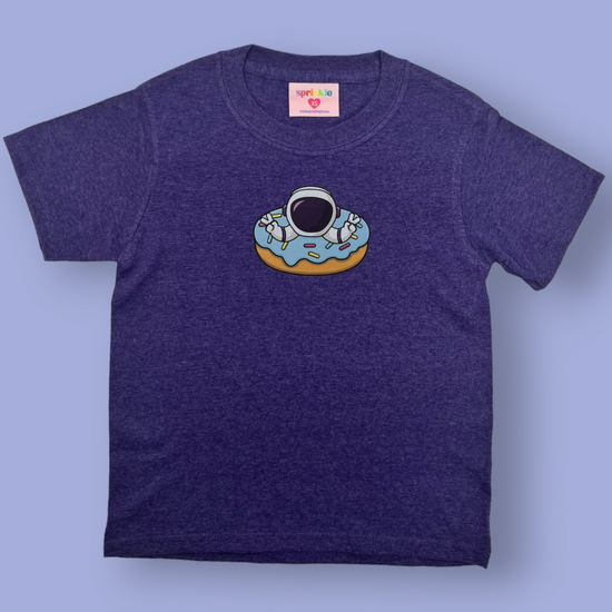 Take off into a galaxy of flavor with our one-of-a-kind Astro-nut Tee. This astronomically delicious tee features an out-of-this-world astronaut hanging out in a donut. You can give a big space salute to your sweet tooth! Blastoff into cuteness overload!